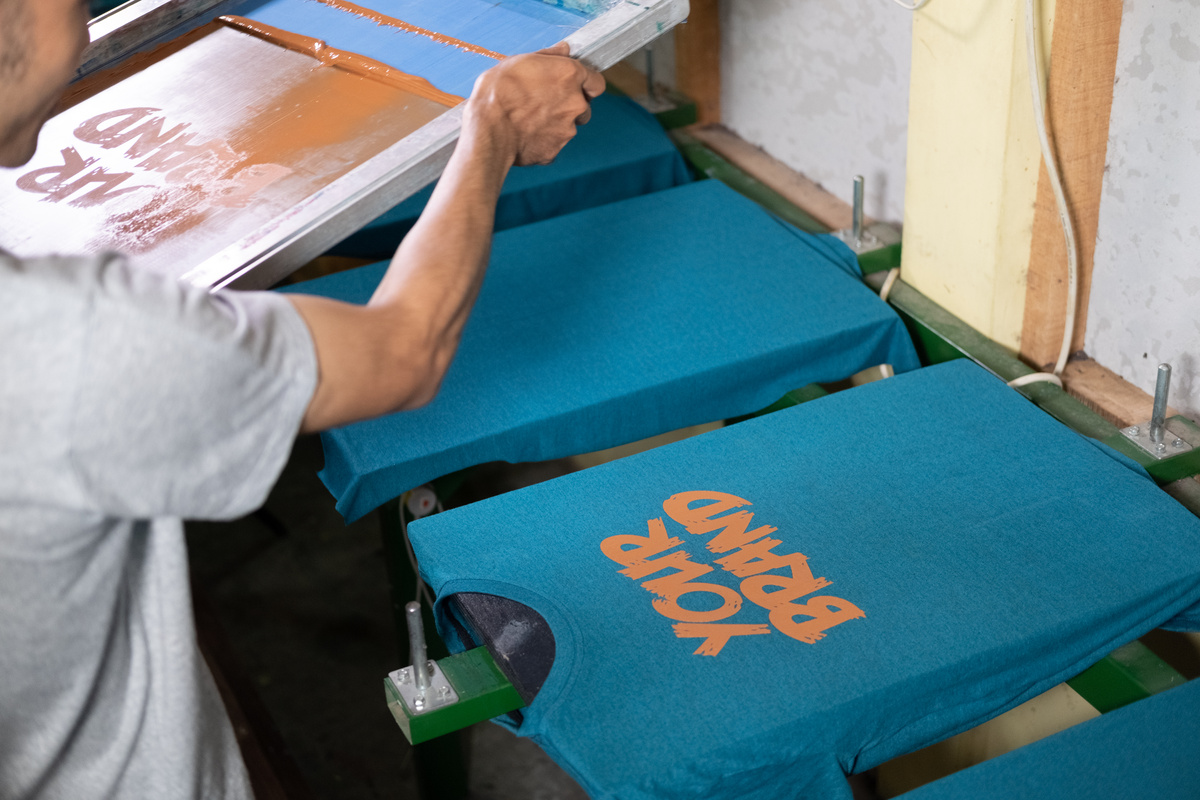 Close up of Male Workers Hold and Lift the Screen Printing Frames after Printing the T-Shirts